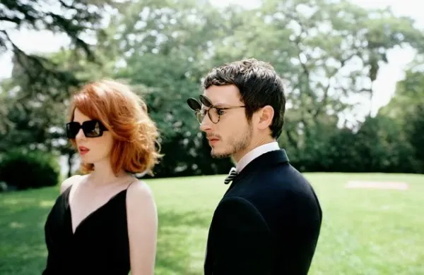 Two people wearing stylish sunglasses and eyeglasses in a park